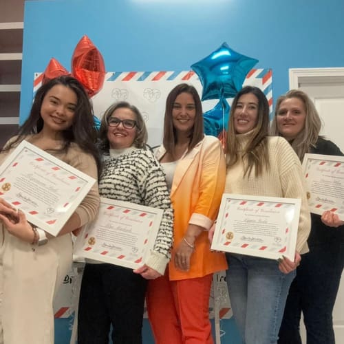 Five smiling women holding certificates